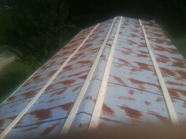 Rusted metal roof panels with new wood purlins before replacement — Storm Damage Roof Repair in Lincoln University by Roofing Brothers