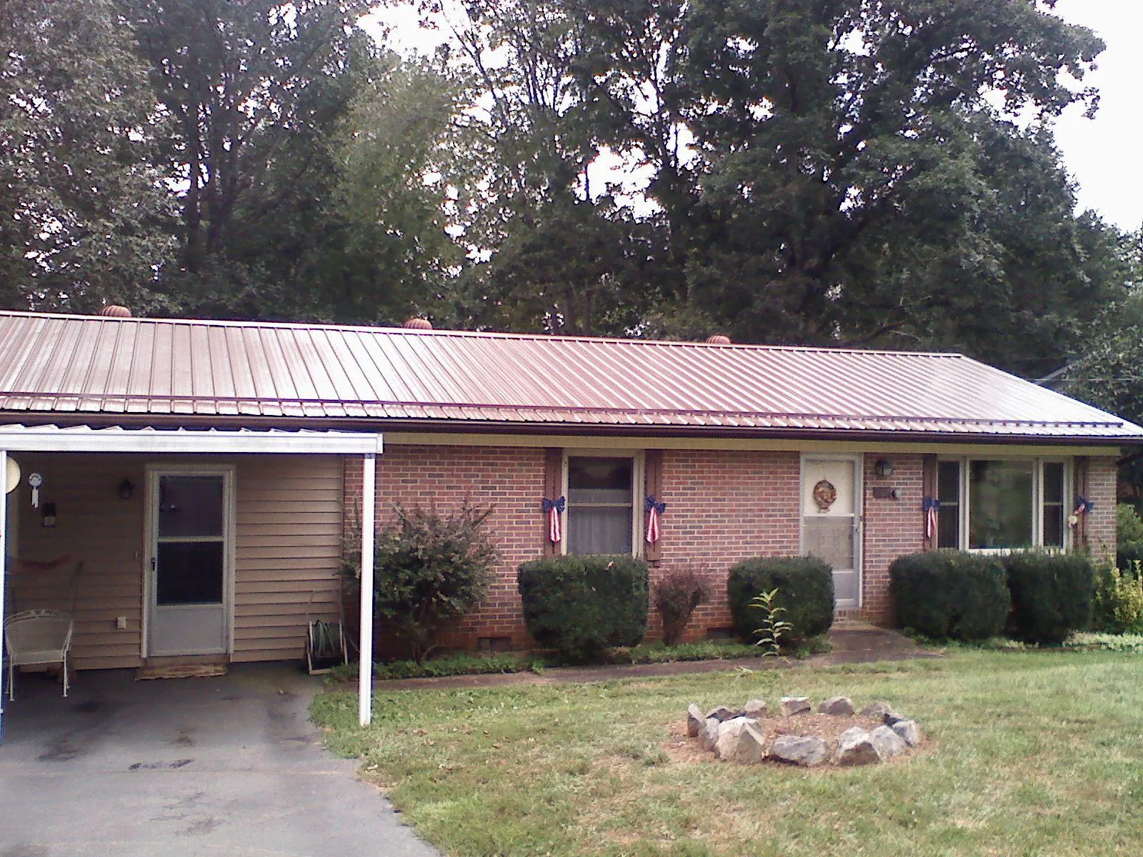 Bronze metal roof and carport on a brick ranch home — Roof Repair work by our crew in Lincoln University